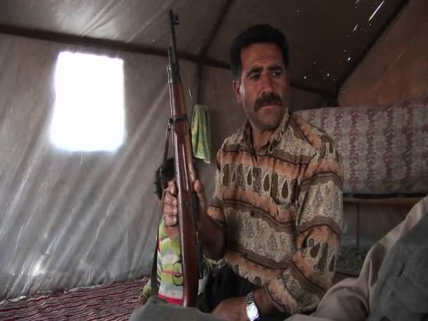 Un homme tient un fusil d'assaut dans une tente — Video
