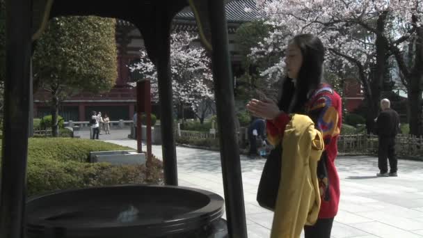 Una mujer reza en un templo en el complejo Senso-ji — Vídeo de stock