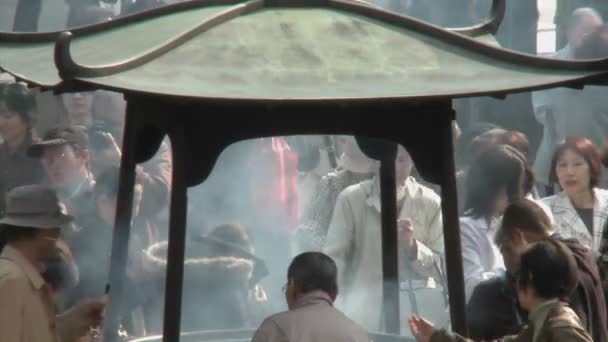 Besökare bränna rökelse i Senso-ji templet — Stockvideo