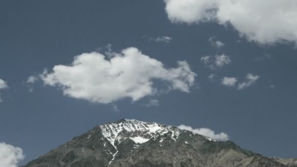 Float σύννεφα πάνω από την κορυφή του βουνού — Αρχείο Βίντεο