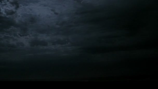 Под грозовыми облаками вспыхивает молния — стоковое видео