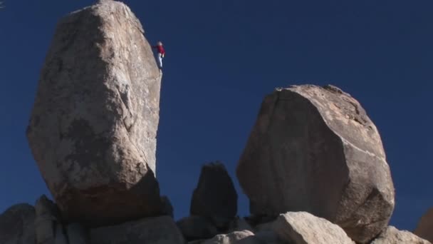 En klättrare börjar att stiga ned en bergväggen. — Stockvideo