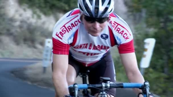 A man rides a bicycle on a stretch of rural highway — Stock Video