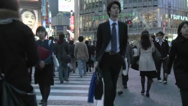 Voetgangers oversteken van de kruising tegenover Shibuya Station — Stockvideo