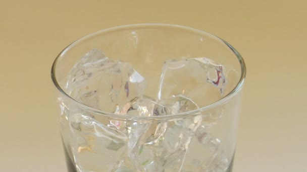 Acqua versata su cubetti di ghiaccio in vetro — Video Stock