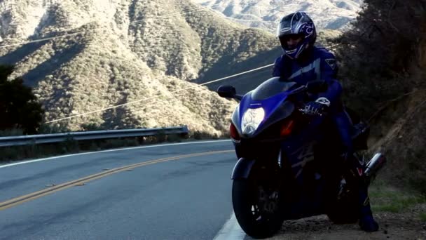 Motocyklista vytáhne na silnici — Stock video