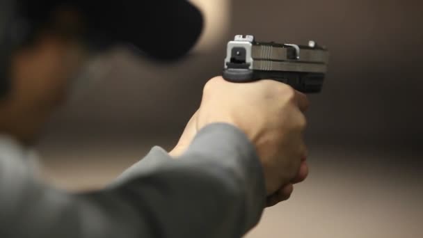 Un hombre dispara una pistola de mano — Vídeo de stock