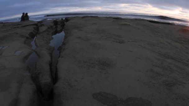 Coppia guardando le onde rotolare sulla spiaggia — Video Stock