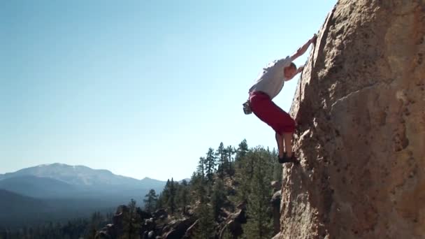 Bir adam bir dağ tarafı tırmanıyor. — Stok video