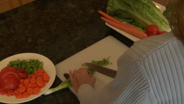 Uma mulher chops cebolas verdes — Vídeo de Stock