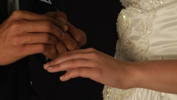 Brudgummen glider en ring på brudens finger. — Stockvideo