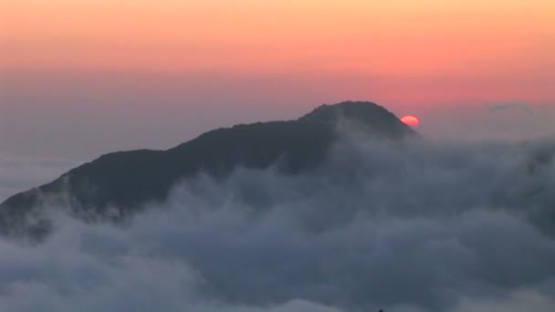 Skyer ruller over en fjellformasjon – stockvideo