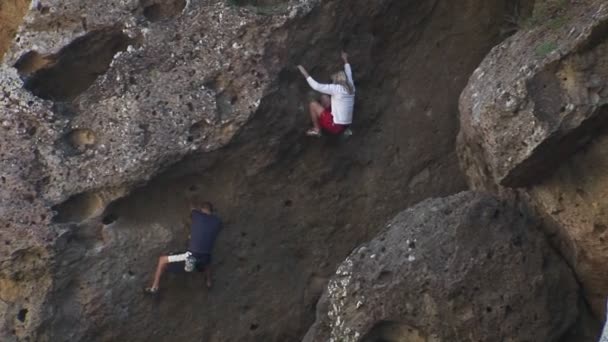 Deux personnes grimpent sur le flanc d'une montagne . — Video