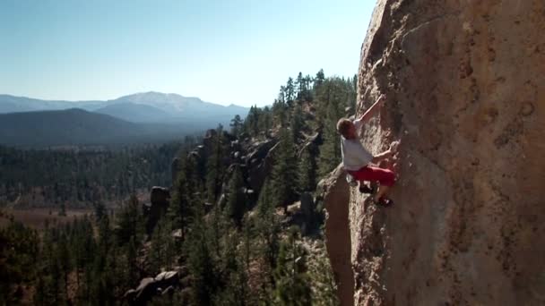 A man climbs up the side of a mountain. — Stock Video