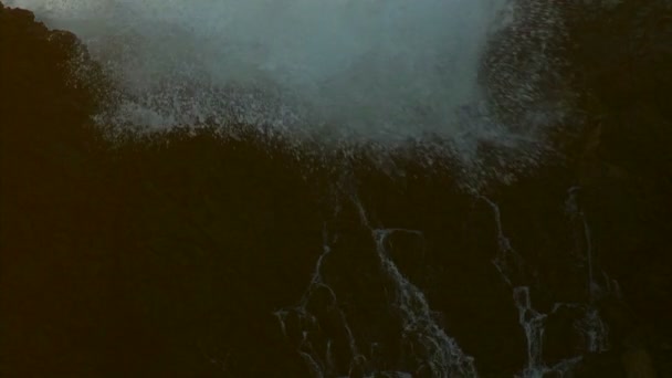 Хвилі розбиваються по скелях — стокове відео