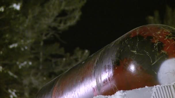 Um cavaleiro de snowboard desliza através de um cilindro de metal . — Vídeo de Stock
