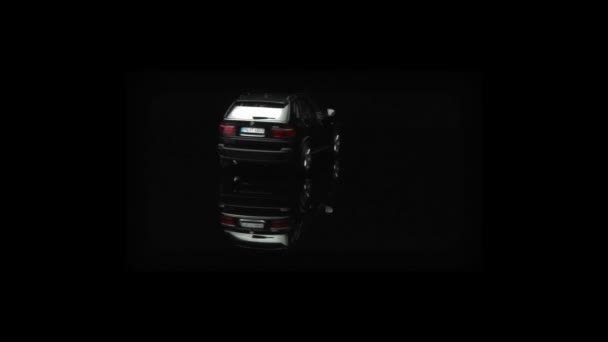 Чорний Bmw позашляховик спинами на дисплеї у всі чорні кімнати — стокове відео
