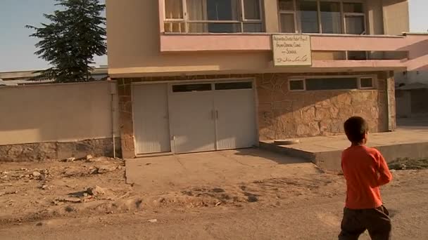 Un niño vuela una cometa frente a un edificio residencial — Vídeos de Stock