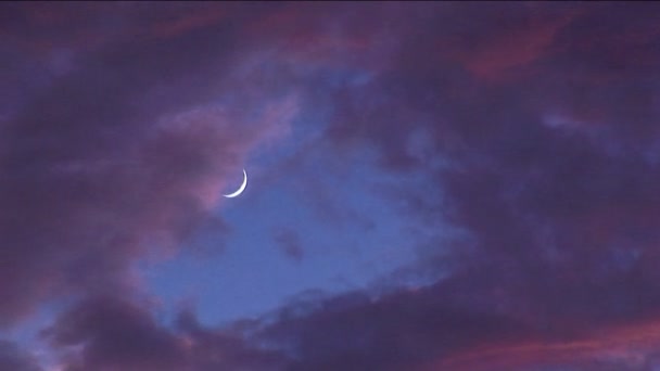 Gekleurde wolken langs een halve maan vegen op gouden uur — Stockvideo