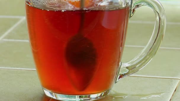 Suiker gegoten in een glas kopje thee — Stockvideo