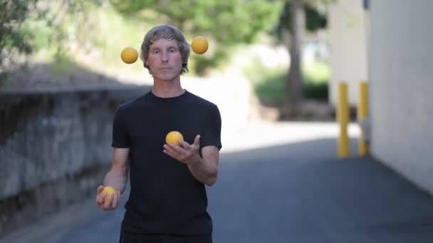 Mens doet een jongleren daad met ballen — Stockvideo