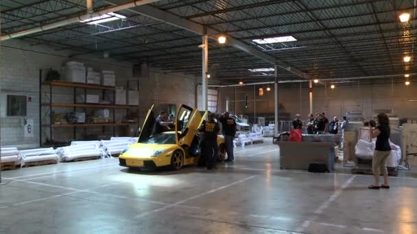 Des agents saisissent une Lamborghini dans une installation portuaire — Video