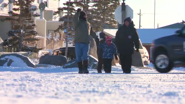 Folk går längs en snöig väg — Stockvideo