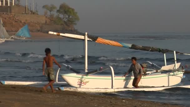 Jongens duwen een vissersboot — Stockvideo