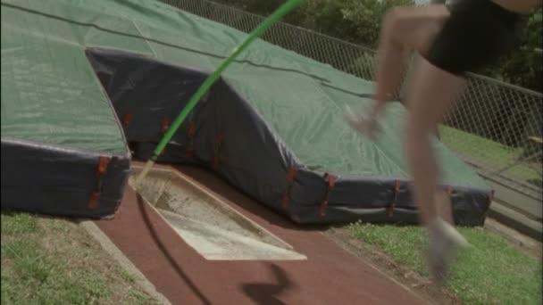 Un jeune homme exécute un saut à perche — Video