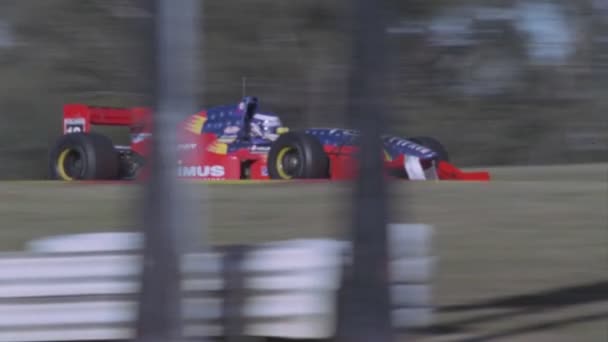 Een racewagen snelheden van een baan — Stockvideo