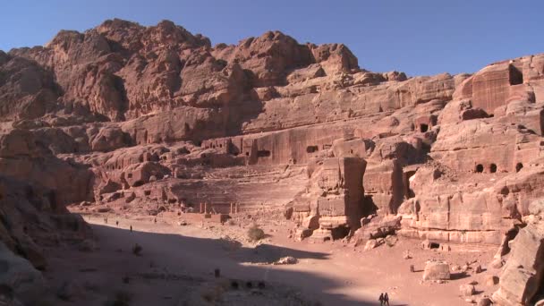 Folk rida åsnor nära nabateanska ruins — Stockvideo