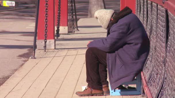 Um sem-abrigo senta-se numa ponte — Vídeo de Stock