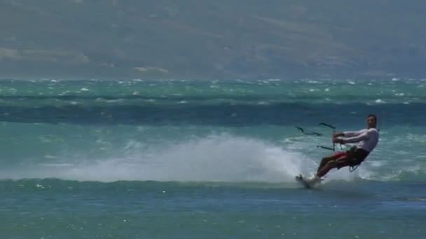 Een windsurfer glijdt langs de Oceaan — Stockvideo