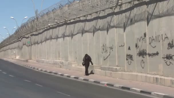 Une femme marche le long de la barrière entre Israël et les territoires palestiniens . — Video