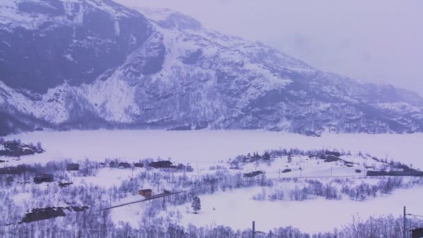 Um trem viaja através de uma paisagem nevada — Vídeo de Stock