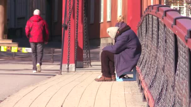 Een dakloze zit op een brug — Stockvideo