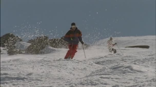 Лыжники бегут вниз по трассе — стоковое видео
