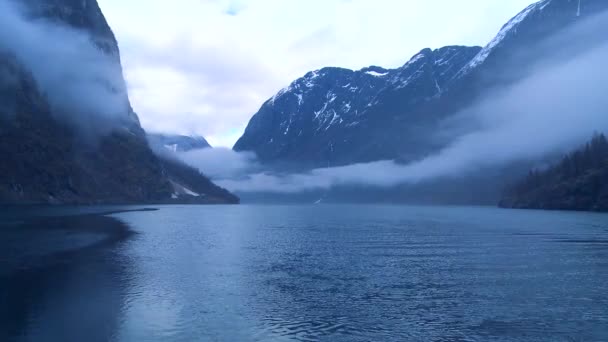 Wolken en mist hangen over een fjord — Stockvideo