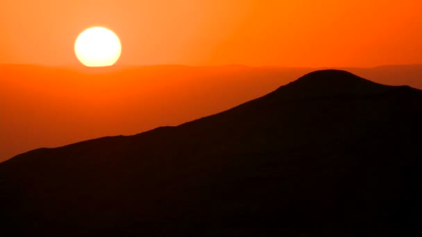 Puesta de sol detrás de una silueta de montaña — Vídeos de Stock