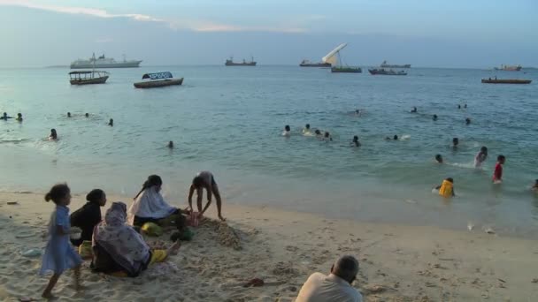 Barnen leker och simmar på stranden — Stockvideo