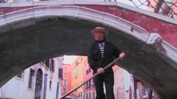 Гондольер гребёт на гондоле под мостом — стоковое видео