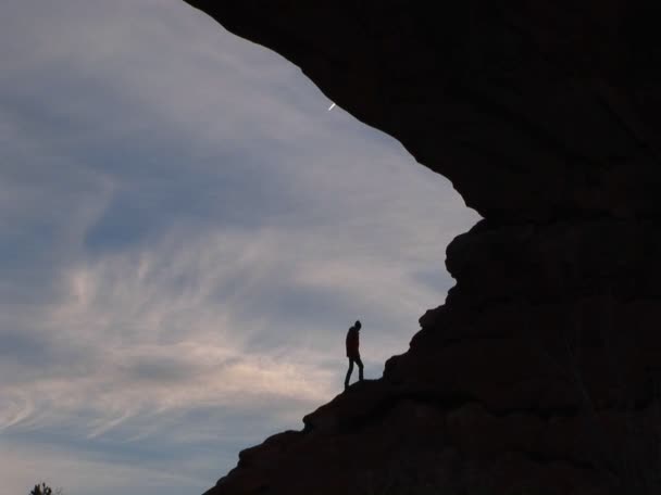 Турист поднимается на скалистый склон — стоковое видео