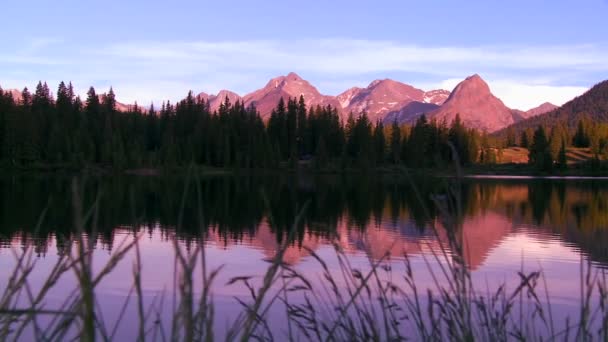 Montañas reflejadas en un lago alpino — Vídeo de stock