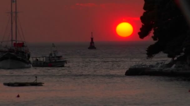 Sol se sienta justo por encima del agua — Vídeo de stock