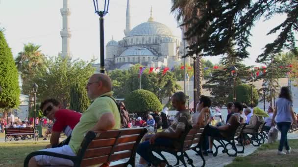 Пешеходы сидят на скамейках возле Голубой мечети — стоковое видео