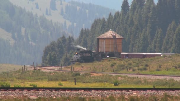 Поезд проходит водонапорную башню — стоковое видео