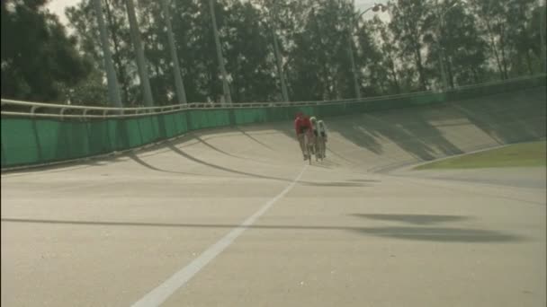 Ciclistas corren alrededor de una pista — Vídeo de stock