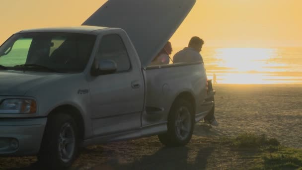 Ett par sitter på flatbädd pickup truck — Stockvideo