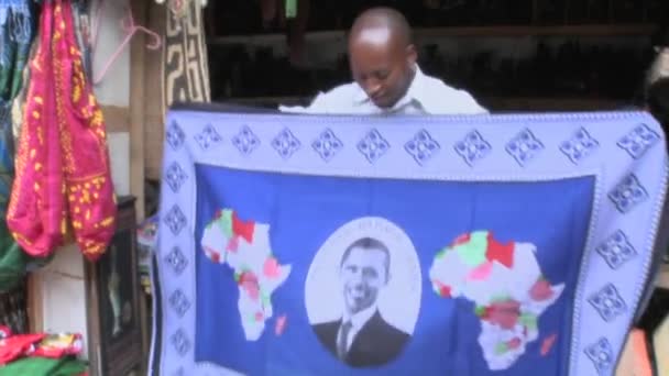 Ο πωλητής κρατά ψηλά μια κουβέρτα με Barack Obama εικόνα — Αρχείο Βίντεο