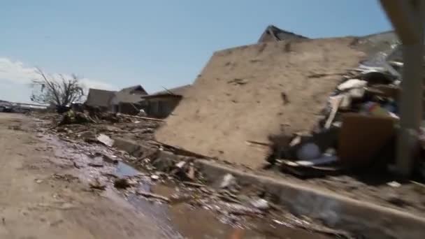 Les gens ramassent à travers les ruines des maisons — Video